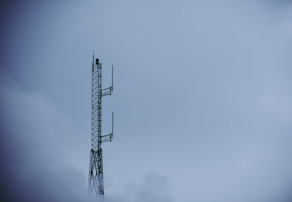 Telecommunication tower reaching into a cloudy sky, capturing modern technological infrastructure.